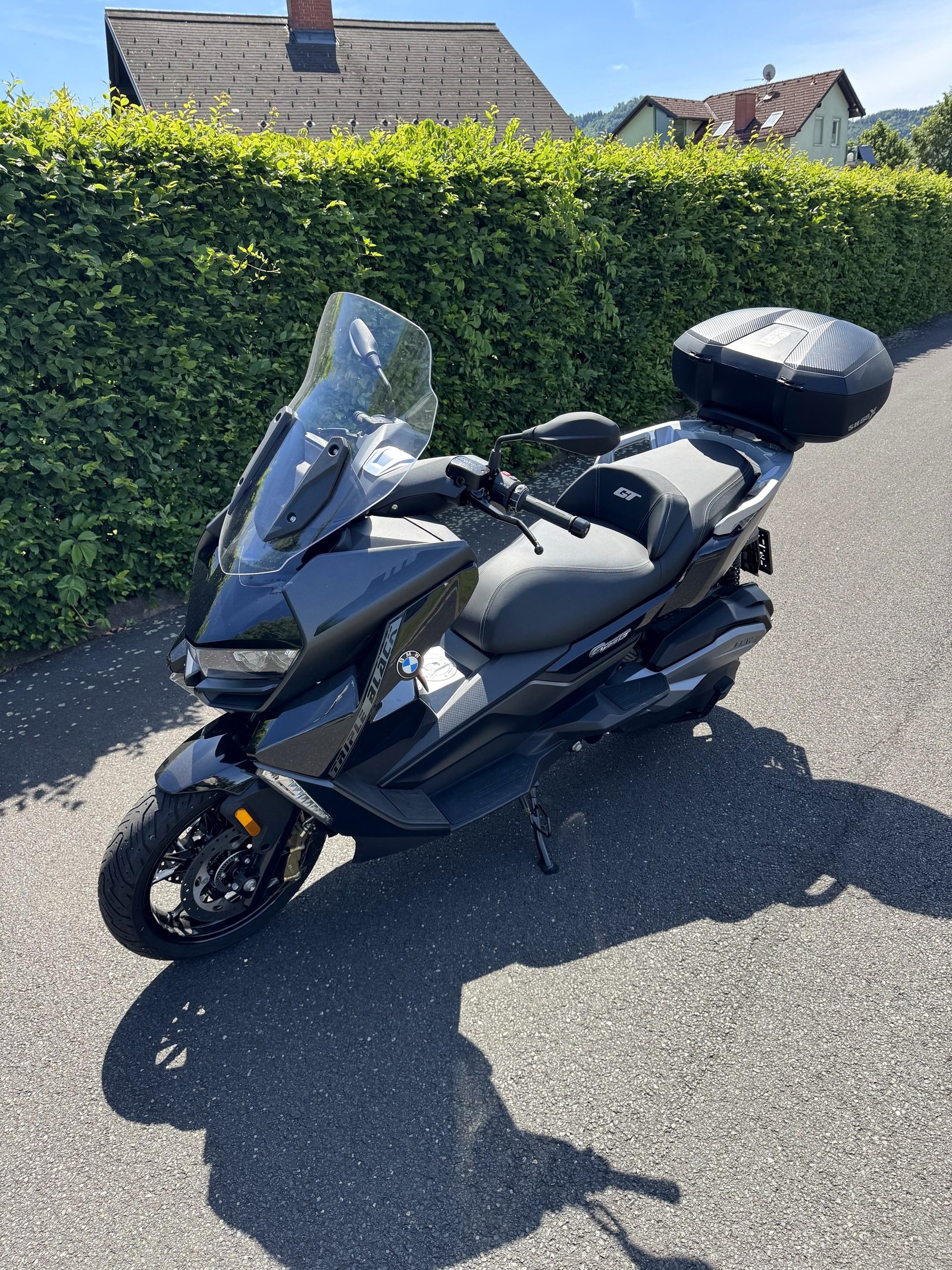 BMW C 400 GT in Schwarz mit Topcase, Drei-Viertel-Frontansicht bei Tageslicht